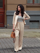 a lady wears a beige blazer with matching pants